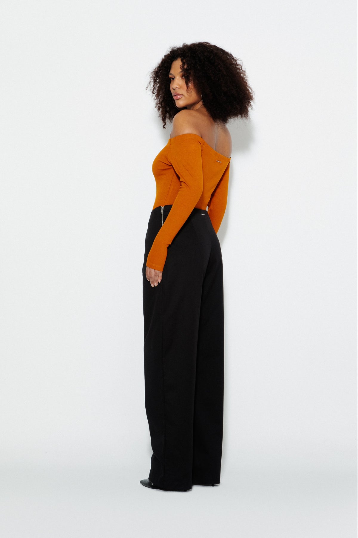 Modelo usando Calça Belly Button e Blusa Ombro a Ombro Mostarda Karoline Vitto, vista lateral