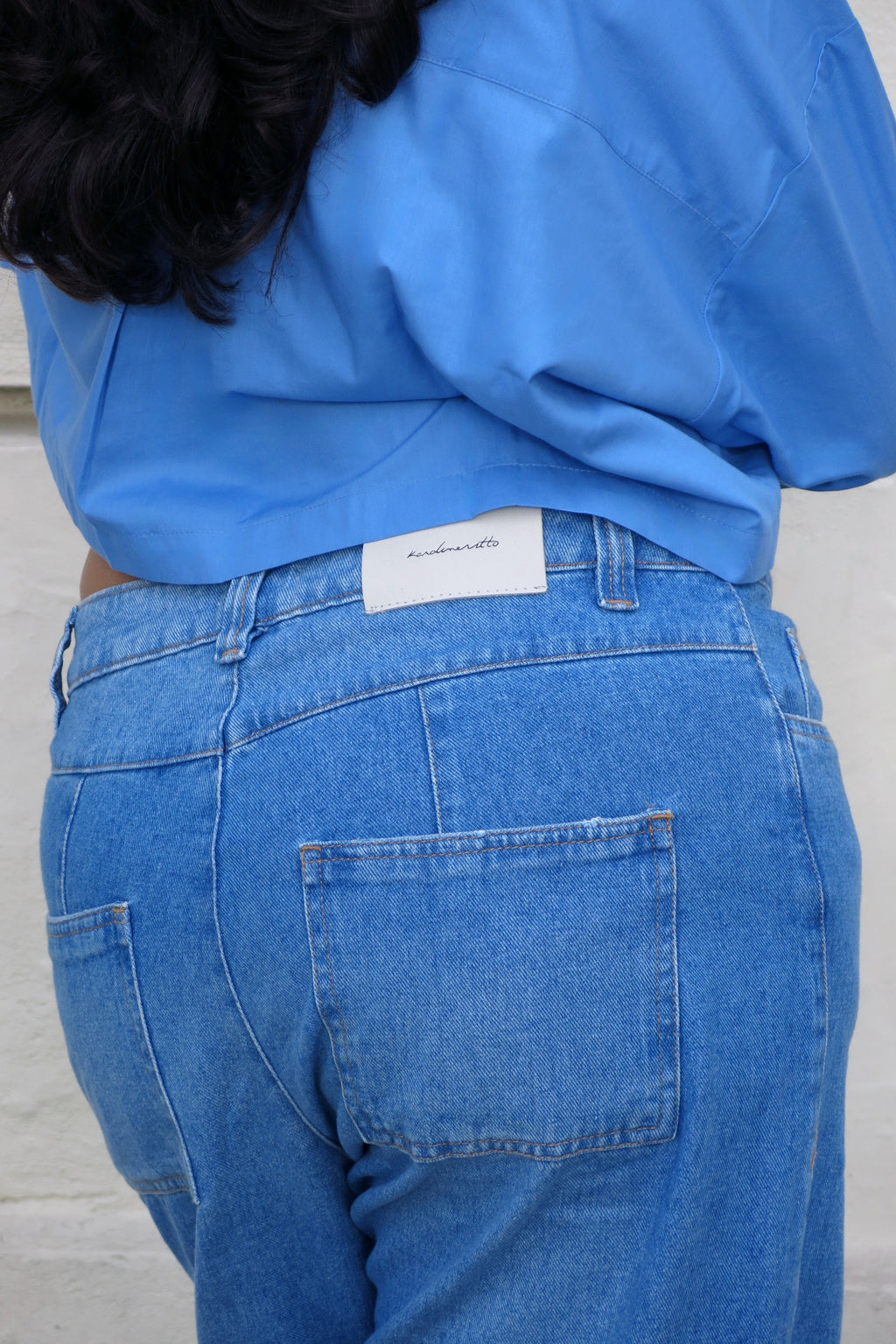 Detalhe do bolso traseiro e etiqueta da Calça Jeans Reta Cropped Karoline Vitto