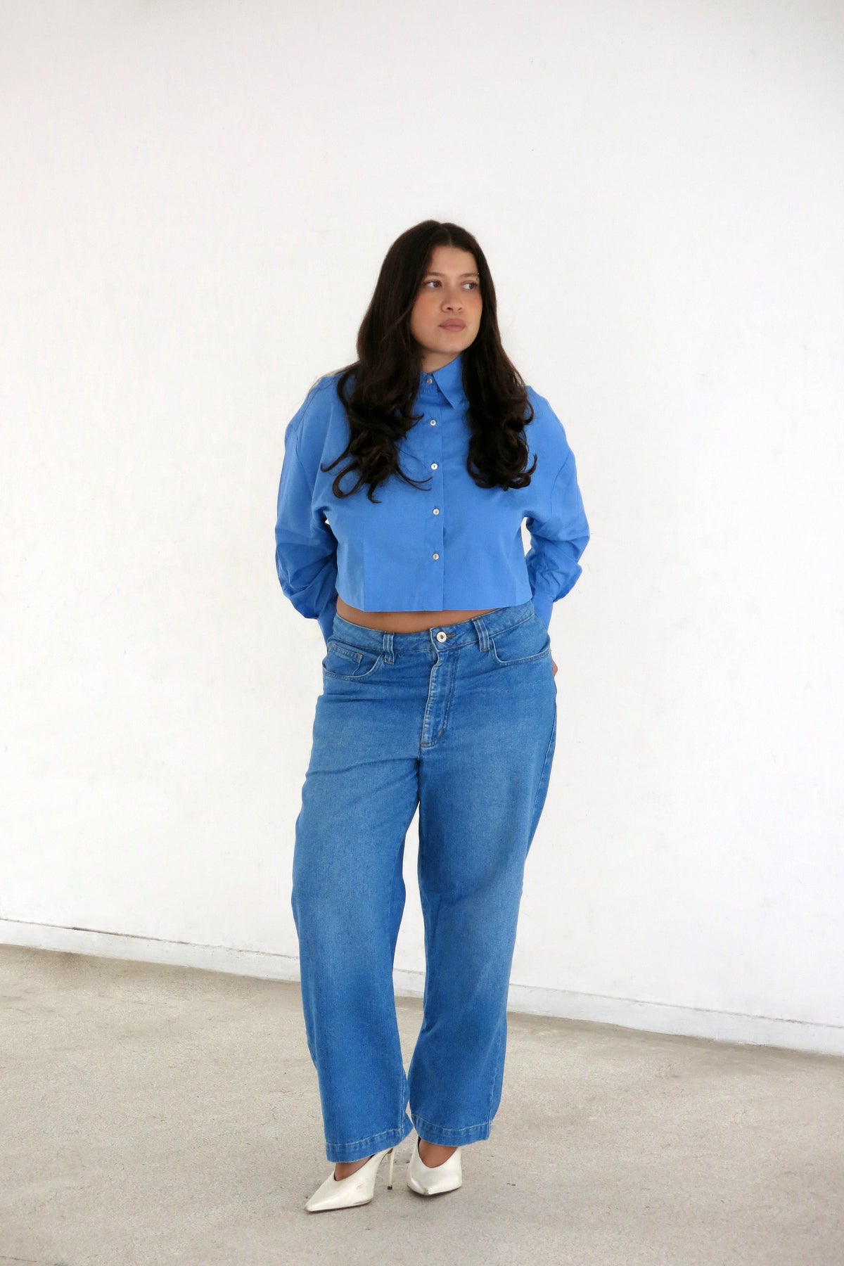 Modelo usando Calça Jeans Reta Cropped Karoline Vitto, vista frontal, ela está combinando com Camisa Cropped Manga Longa Azul