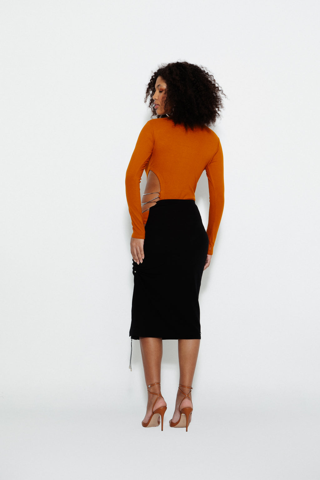 Modelo usando Saia Midi Barely There Preta e Body Barely There Karoline Vitto, vista traseira