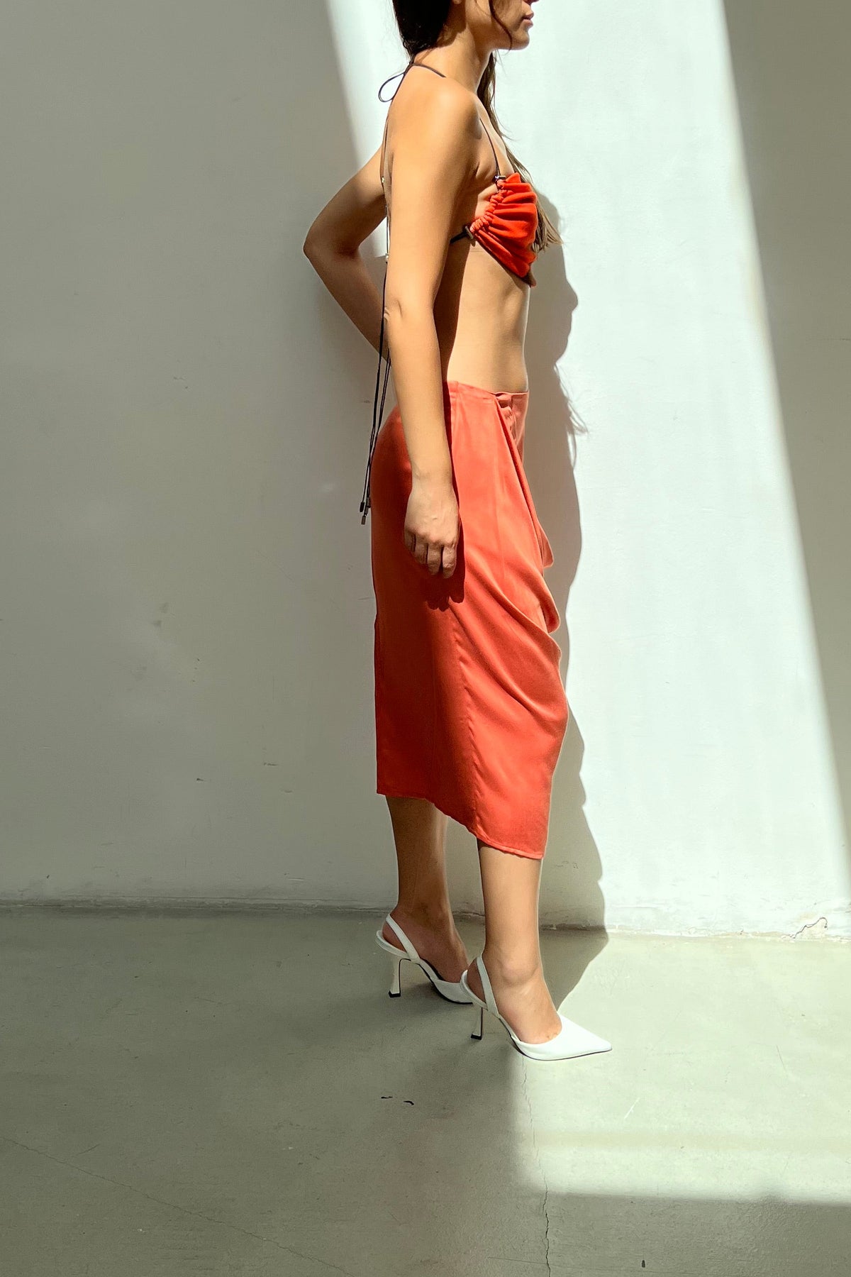 Modelo usando Saia Degagê Exagerado Laranja Karoline Vitto, vista lateral